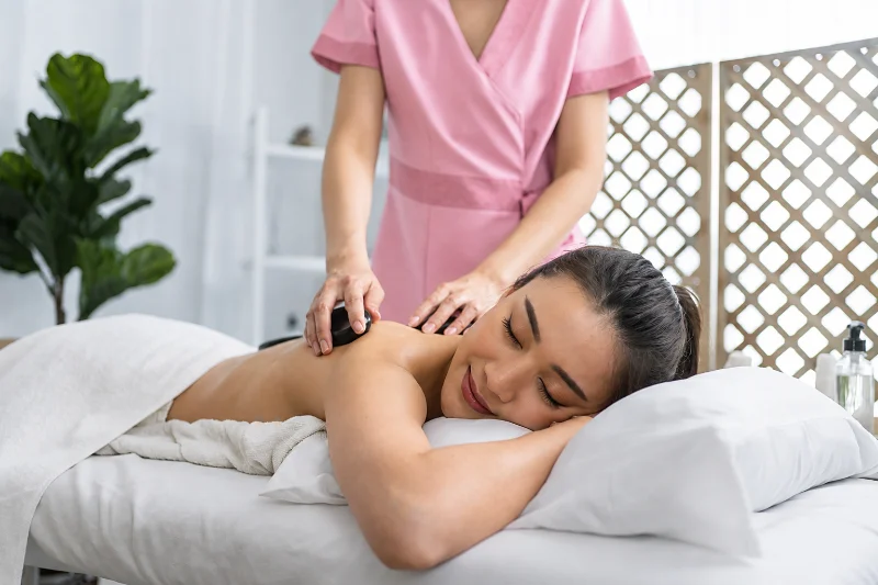Warm stone worked across the shoulders during a Thai hot stone massage