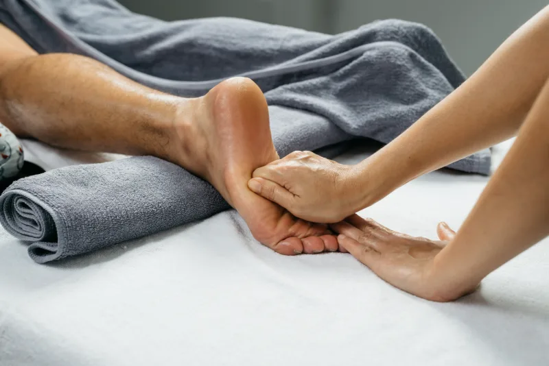 Therapist working on client's foot during Thai reflexology massage